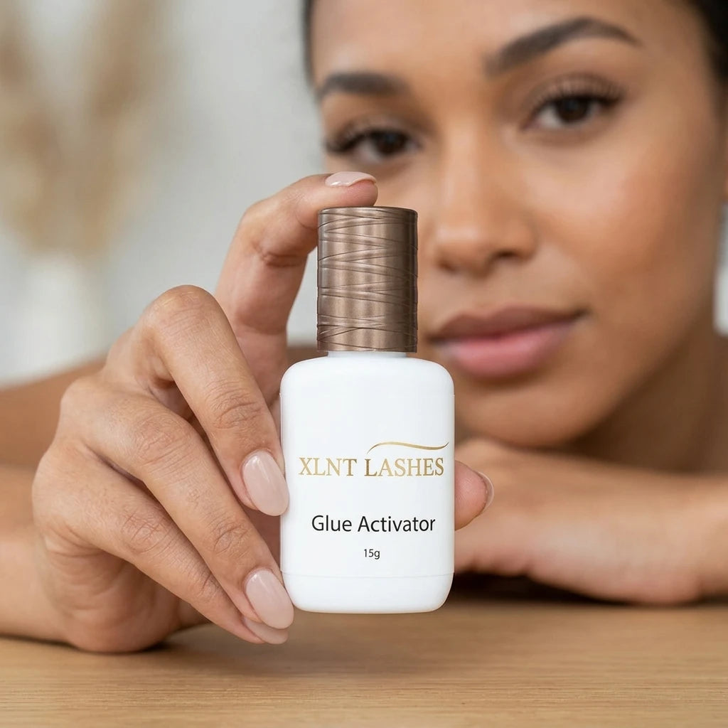 XLNT Lashes Glue Activator 15g bottle held by a hand, professional lash extension adhesive accelerator.