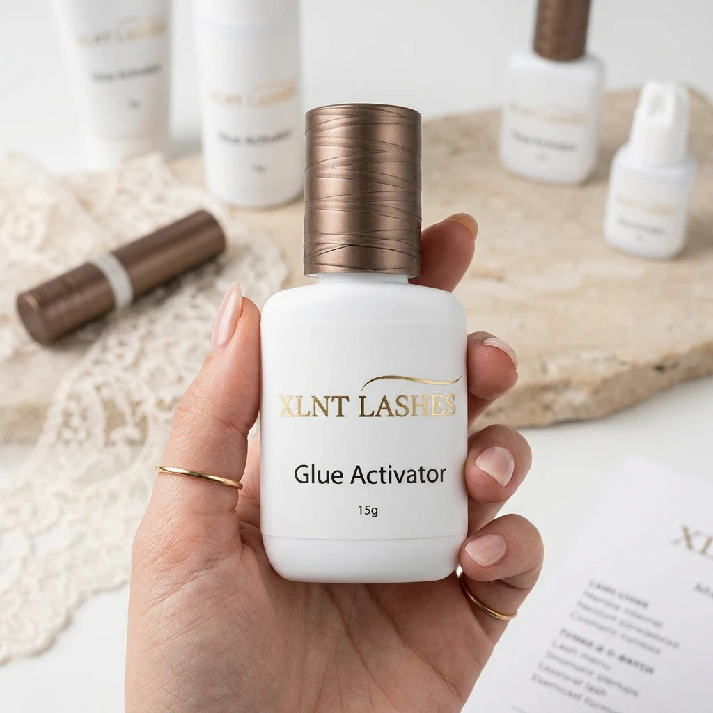 XLNT LASHES Glue Activator 15g bottle with bronze cap held in hand, ideal for eyelash extension application.