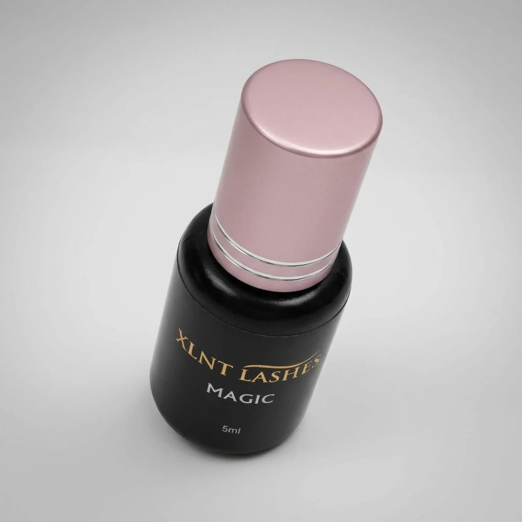 Magic Glue 5ml - 02-1 Sek i svart flaska med rosa metallkork och guldtext mot en ljusgrå bakgrund.
