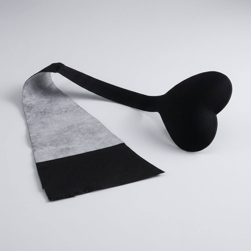 Svart självhäftande engångs C-string i hjärtformad design av Chinlon, framifrån.