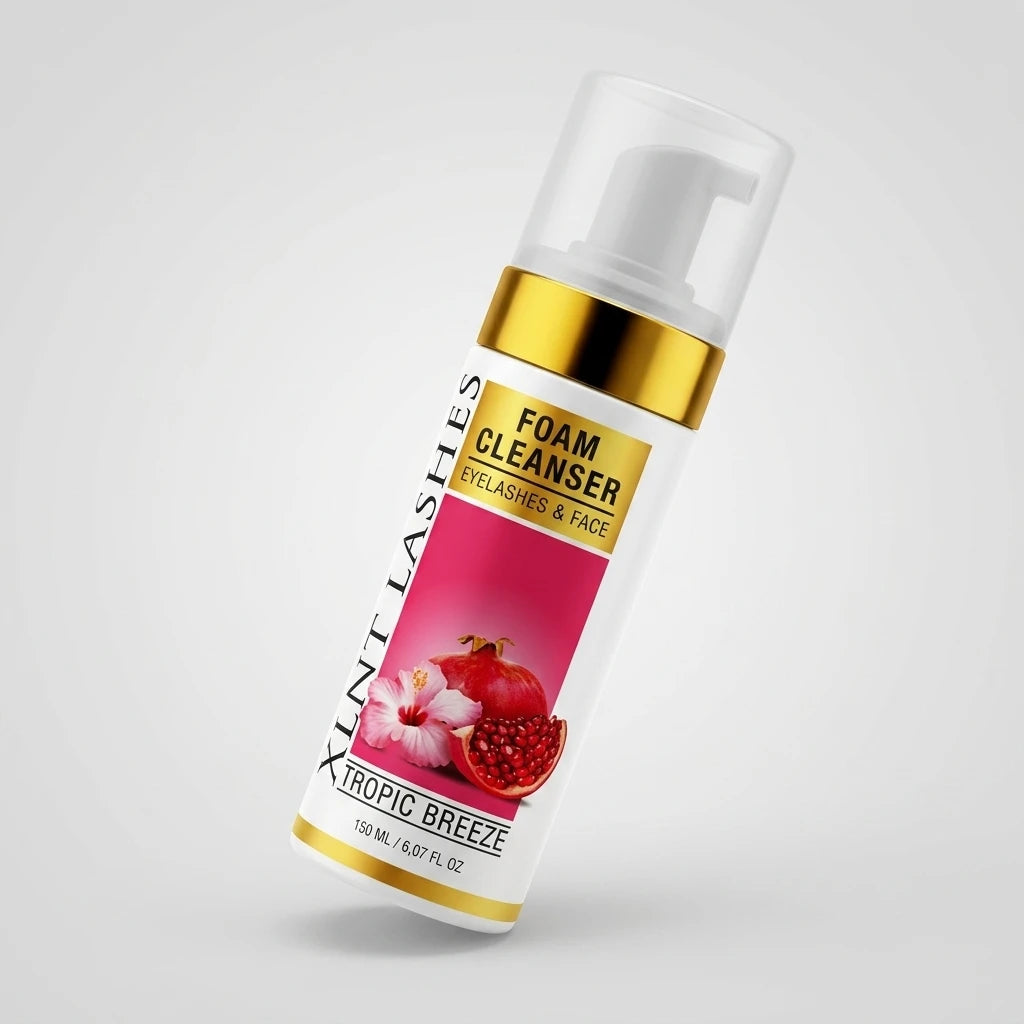 Snedställd vit flaska Fransrengöring Tropic Breeze med gulddetaljer, granatäpple och hibiskus mot ljusgrå bakgrund.