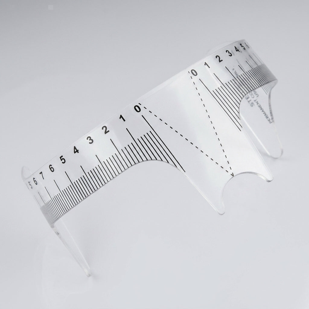 Genomskinlig flexibel brynlinjal Eyebrow Ruler Style 2 med svarta mätlinjer, sedd ovanifrån.