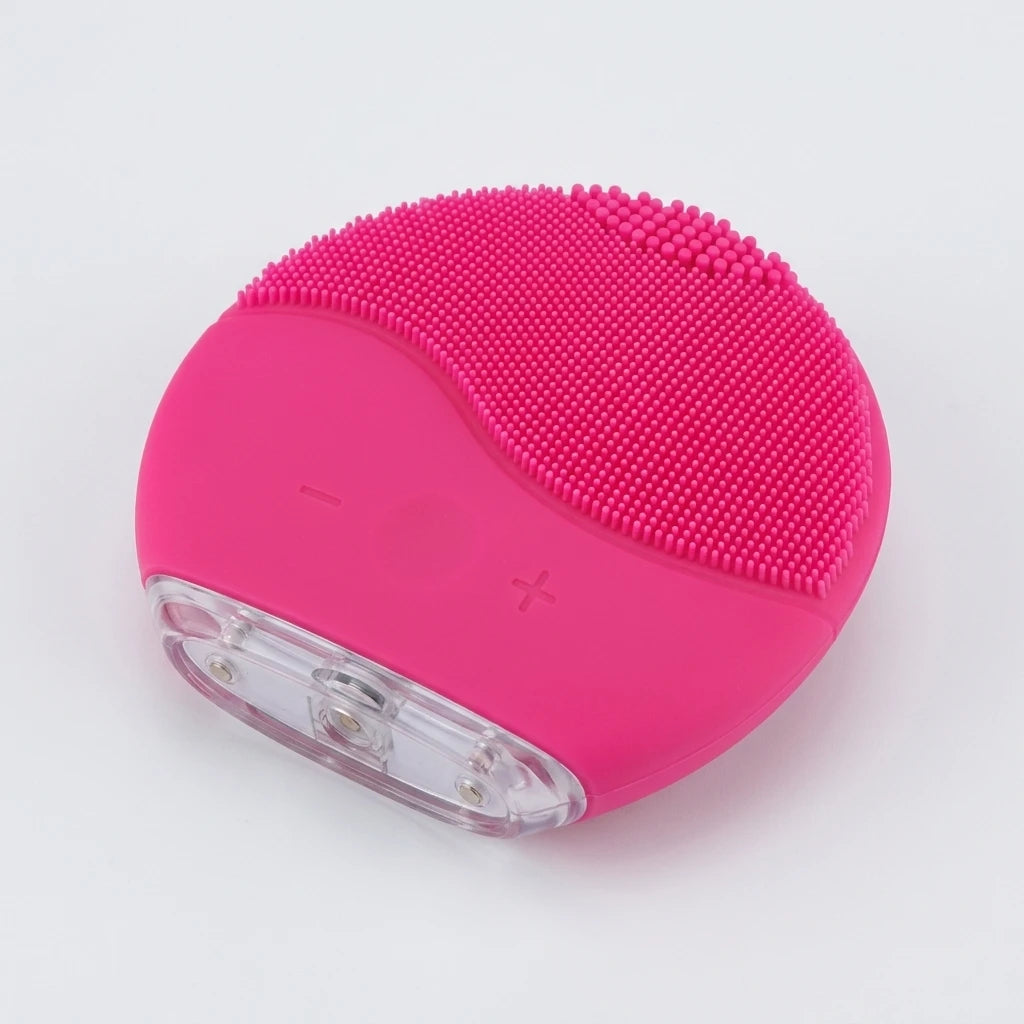 Närbild ovanifrån på rosa silikonborste med fina borststift och reglerknappar för ansiktsrengöring.