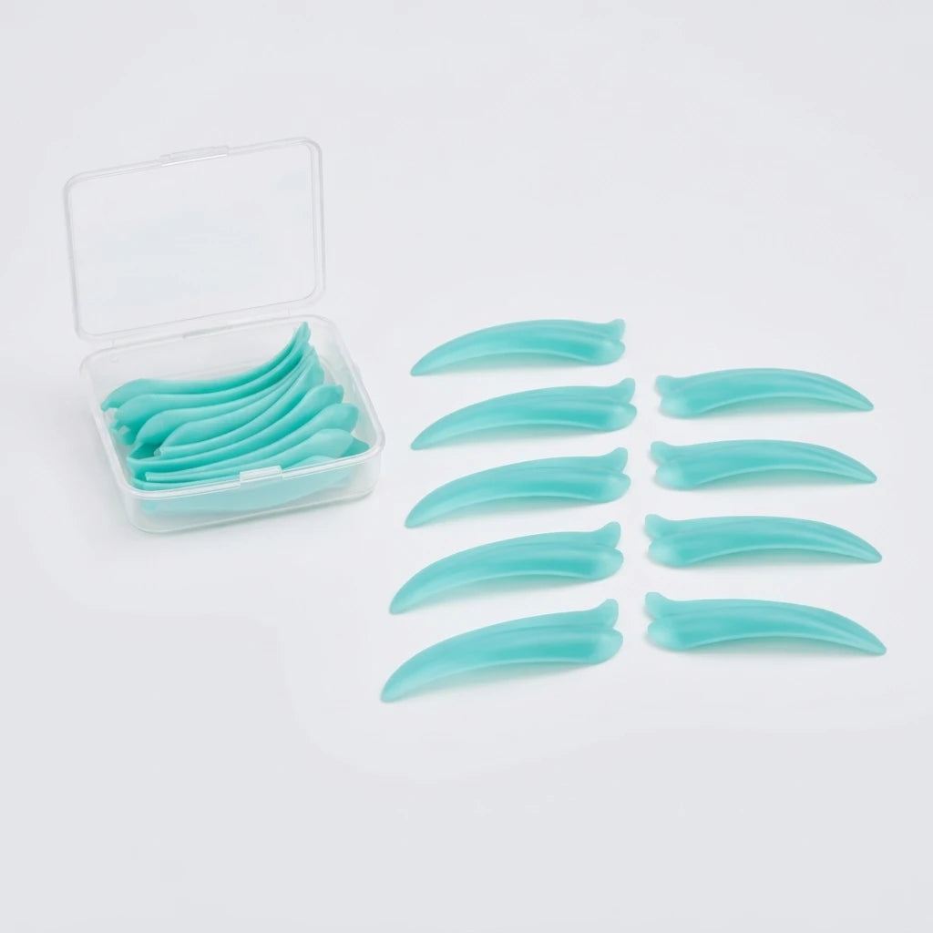 Turkosa Korean Lash lift spole Dolphin i silikon bredvid en genomskinlig ask på vit bakgrund.