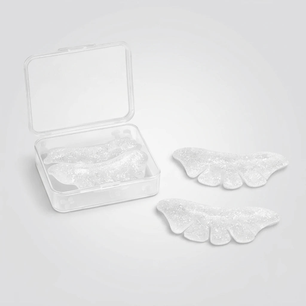 Glittrande Korean Lash Lift Spole Underfransar Butterfly i silikon bredvid en öppen plastask på ljusgrå bakgrund.