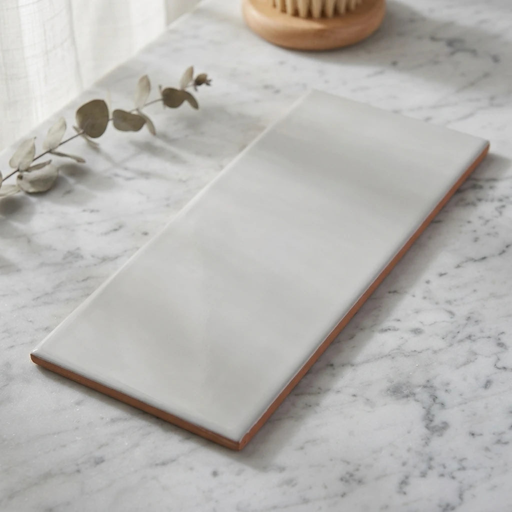 Blank vit fransplatta 10x20 cm med terrakottasidor placerad på marmorbänk med eukalyptuskvist.