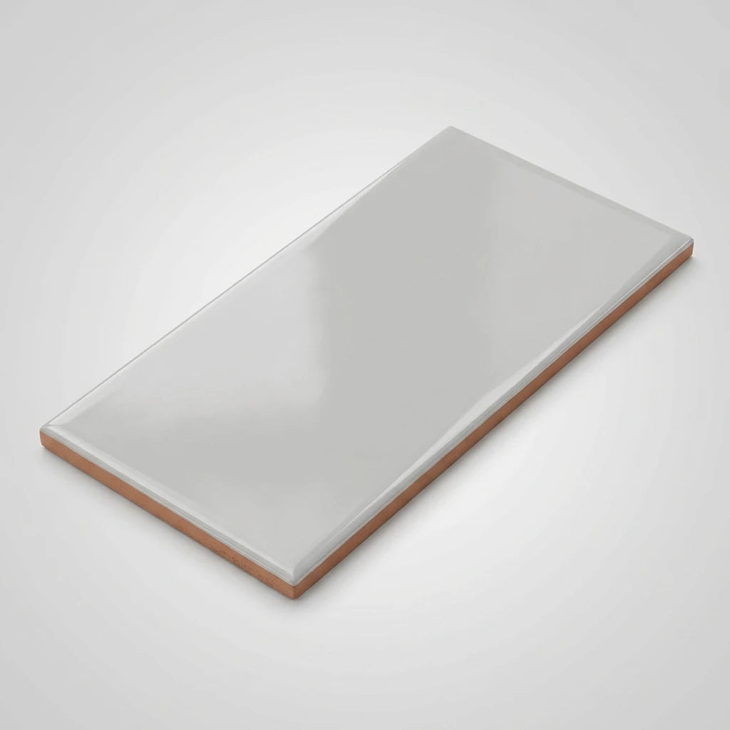 Ljusgrå keramisk fransplatta 10x20 cm med rödbrun lerkant, snedvy ovanifrån på ljus bakgrund.