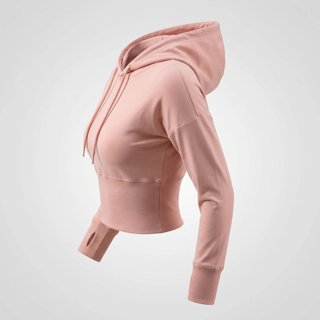 Puderrosa croppad hoodie i profil med bred ribbad midja, lång mudd och tumhål mot ljusgrå bakgrund.
