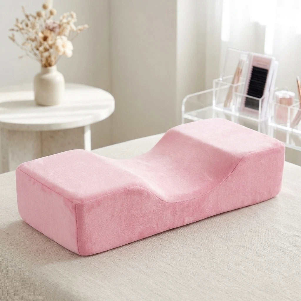 Ergonomisk Franskudde Rosa i mjuk sammet för fransförlängning, placerad på en ljus behandlingsbänk.