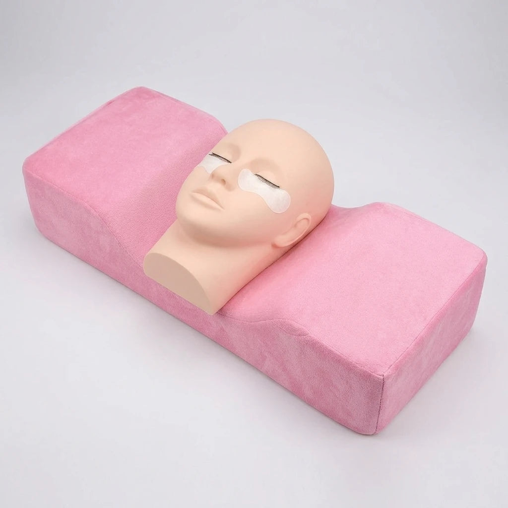 Franskudde Rosa med övningshuvud placerat i kuddens nackkurva, rosa velvet mot vit bakgrund.