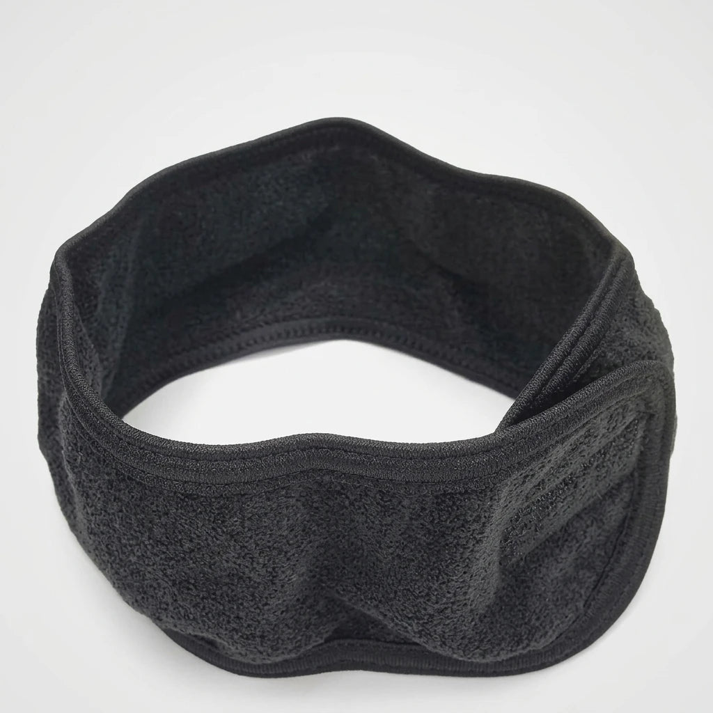 Svart microfiberhårband med kardborreknäppning sett från övre vänster vinkel mot ljus bakgrund.