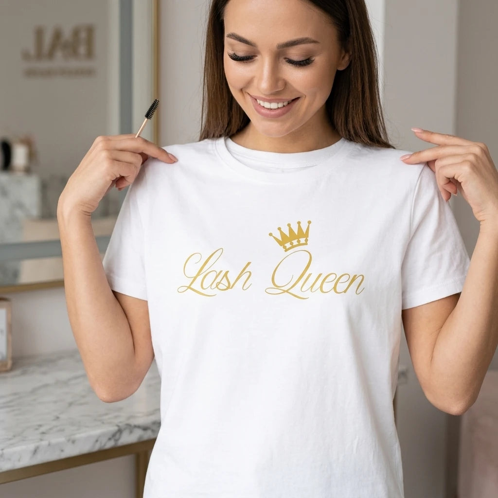 Fransförlängningsstylist i vit Lash Queen-t-shirt håller en fransborste i ljus salongsmiljö.