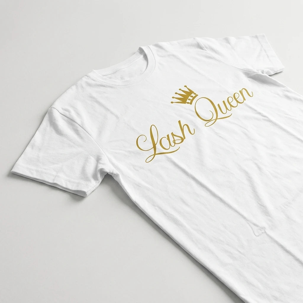Närbild på Lash Queen-trycket i guld med liten krona på vit bomullst-shirt, ljusgrå bakgrund.