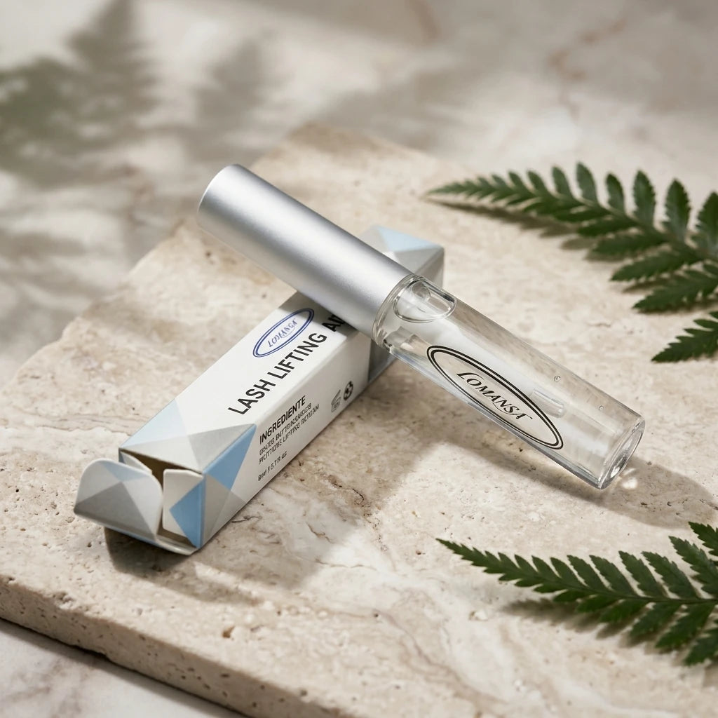 Lomansa Lash Lifting Adhesive clear tube and box on a travertine stone plate with fern leaves.