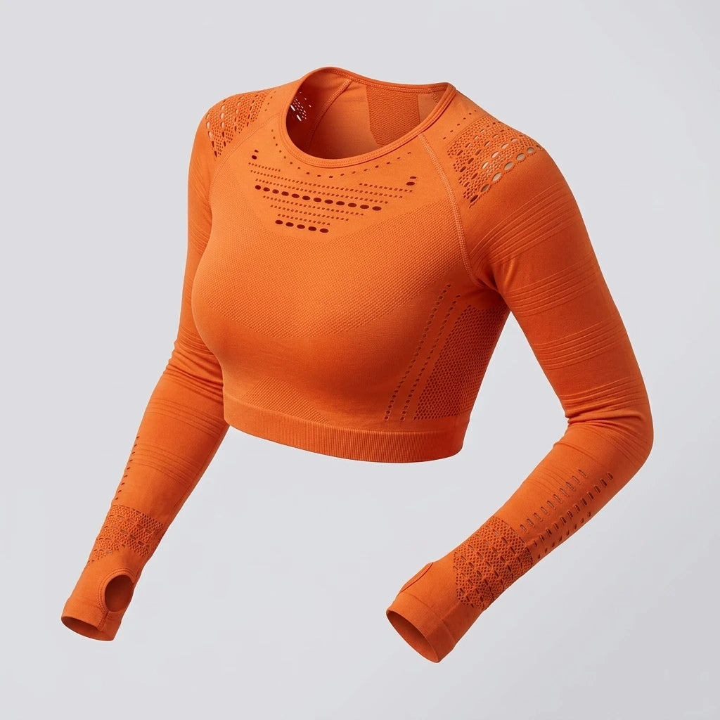 Orange seamless crop top med meshdetaljer och tumhål, produktbild mot ljusgrå bakgrund.