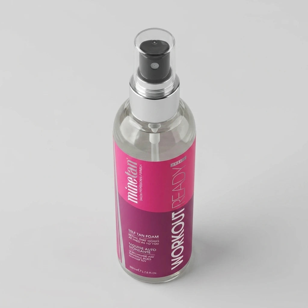 MineTan - Workout Ready Tan Oil i en genomskinlig sprayflaska med rosa etikett mot en ljusgrå bakgrund.