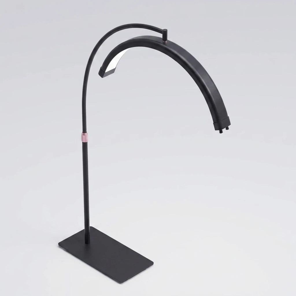 Isometrisk vy av svart LED Moon Light lampa med halvmåneformat ljushuvud och rosa detalj på stativet.