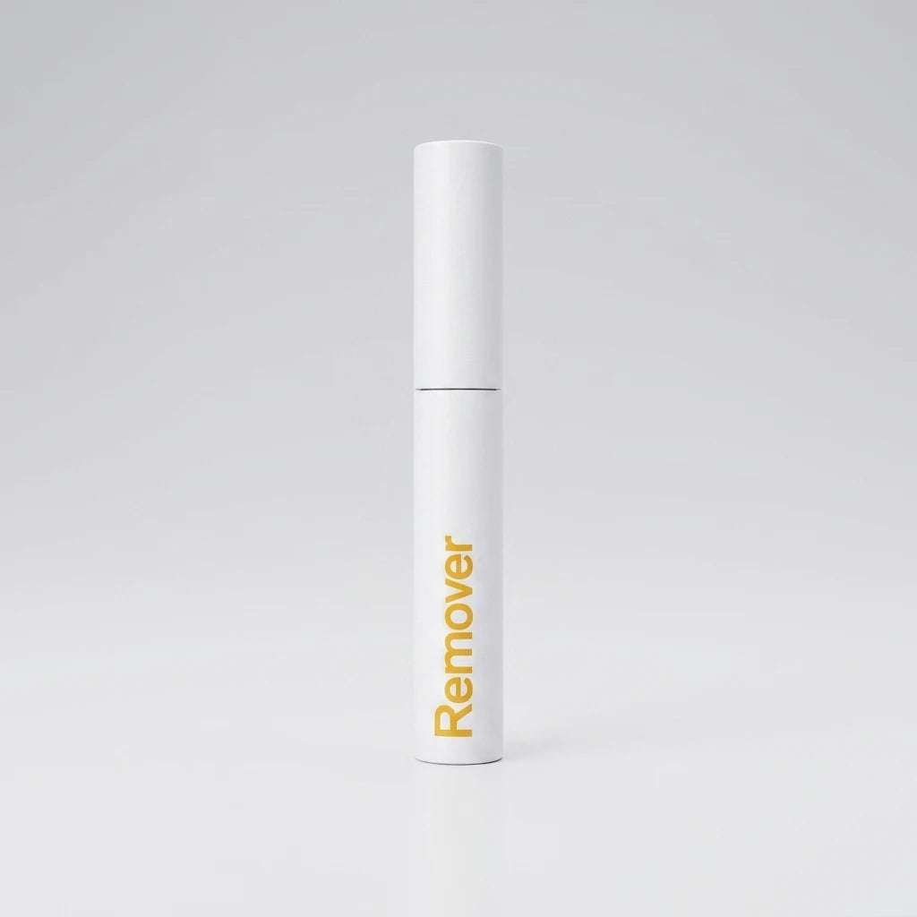 Vit cylindrisk hylsa med gul text för Remover för Easy Lashes, stående mot en ljusgrå bakgrund.