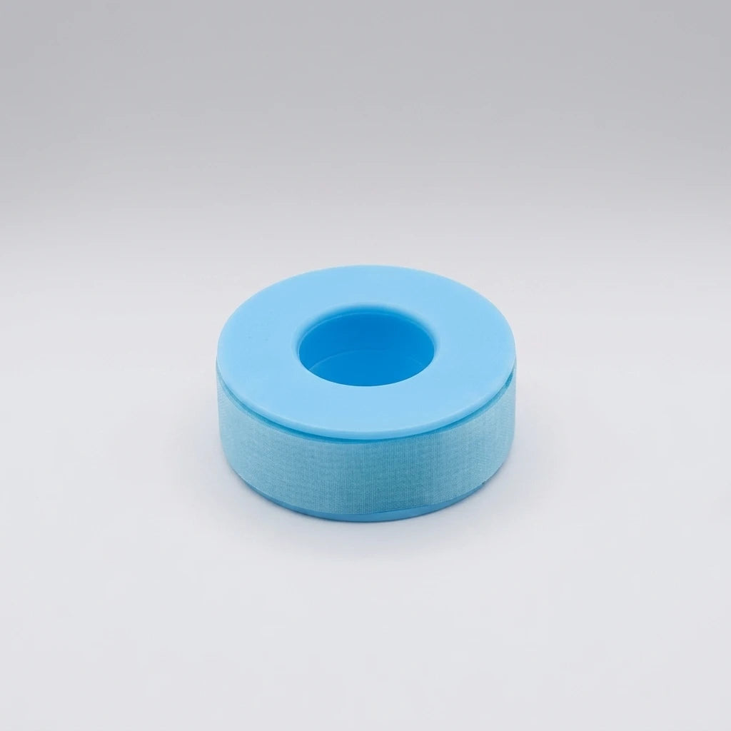 Rulle med ljusblå latexfri silikontejp 2,5 cm bred på plastspole mot ljusgrå bakgrund.
