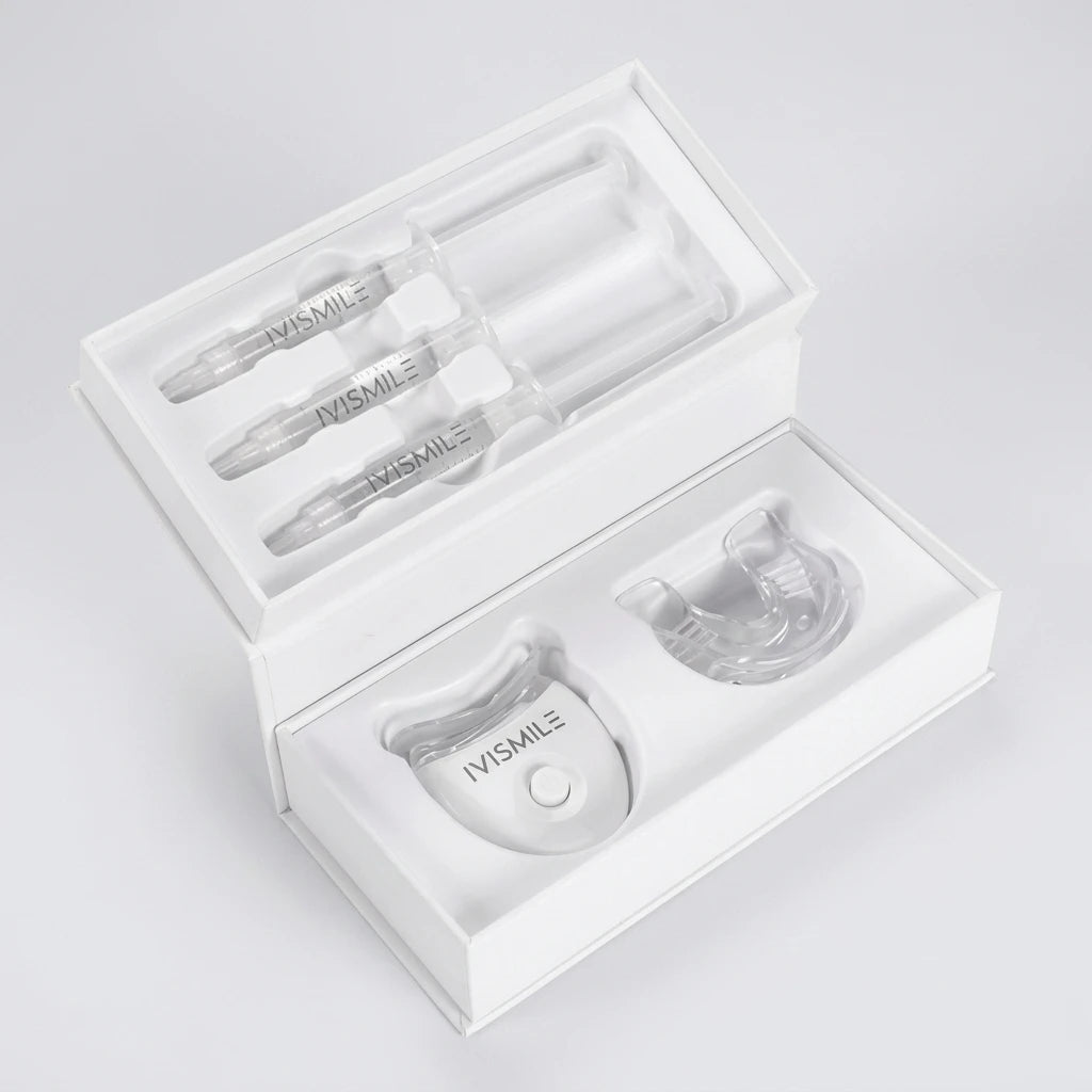Tandblekningskit Ivismile Gold Kit i vit box med tre gelsprutor, en LED-lampa och en genomskinlig tandskena.