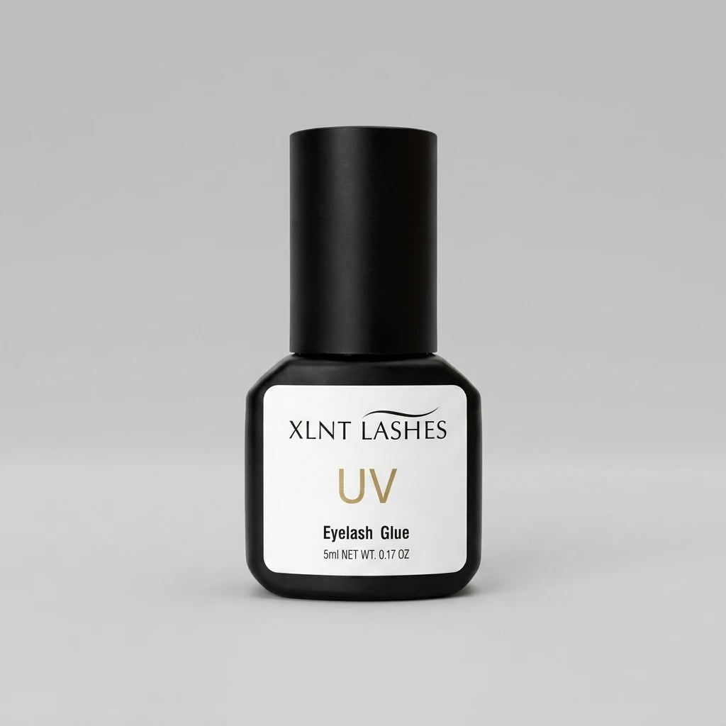 XLNT LASHES UV Glue 5ml Clear – svart flaska med vit etikett mot ljusgrå bakgrund.